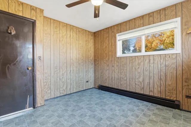 an empty room with a window and ceiling fan
