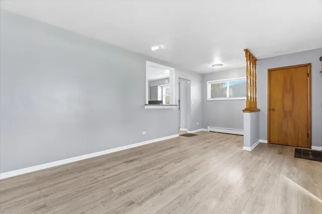 a view of a small space with wooden floor and a window