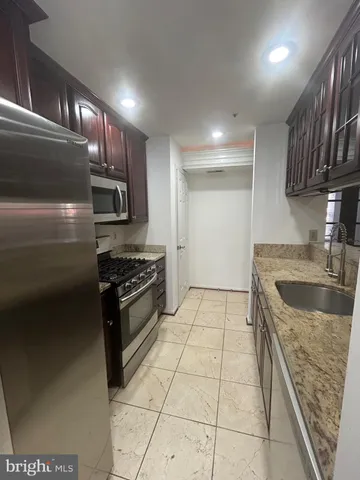 a kitchen with stainless steel appliances granite countertop a sink stove and cabinets