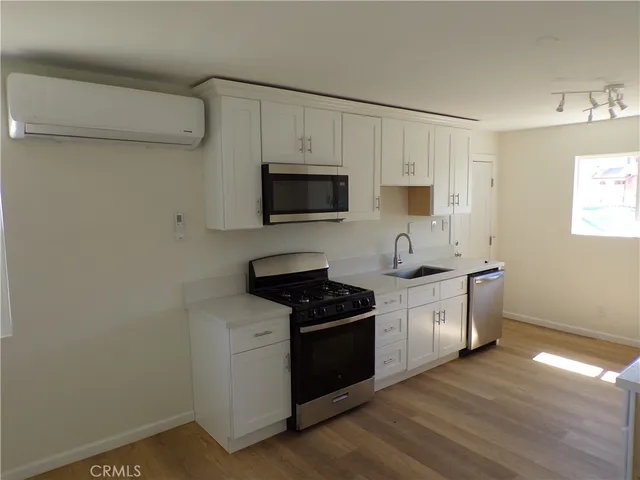 a kitchen with sink a microwave and cabinets