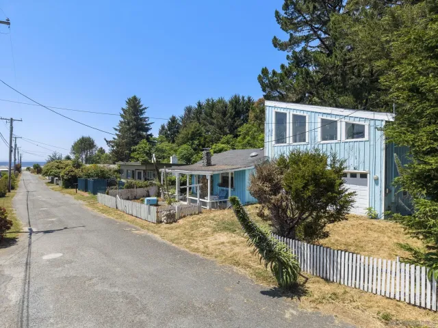 a view of a house with wooden fence next to a yard