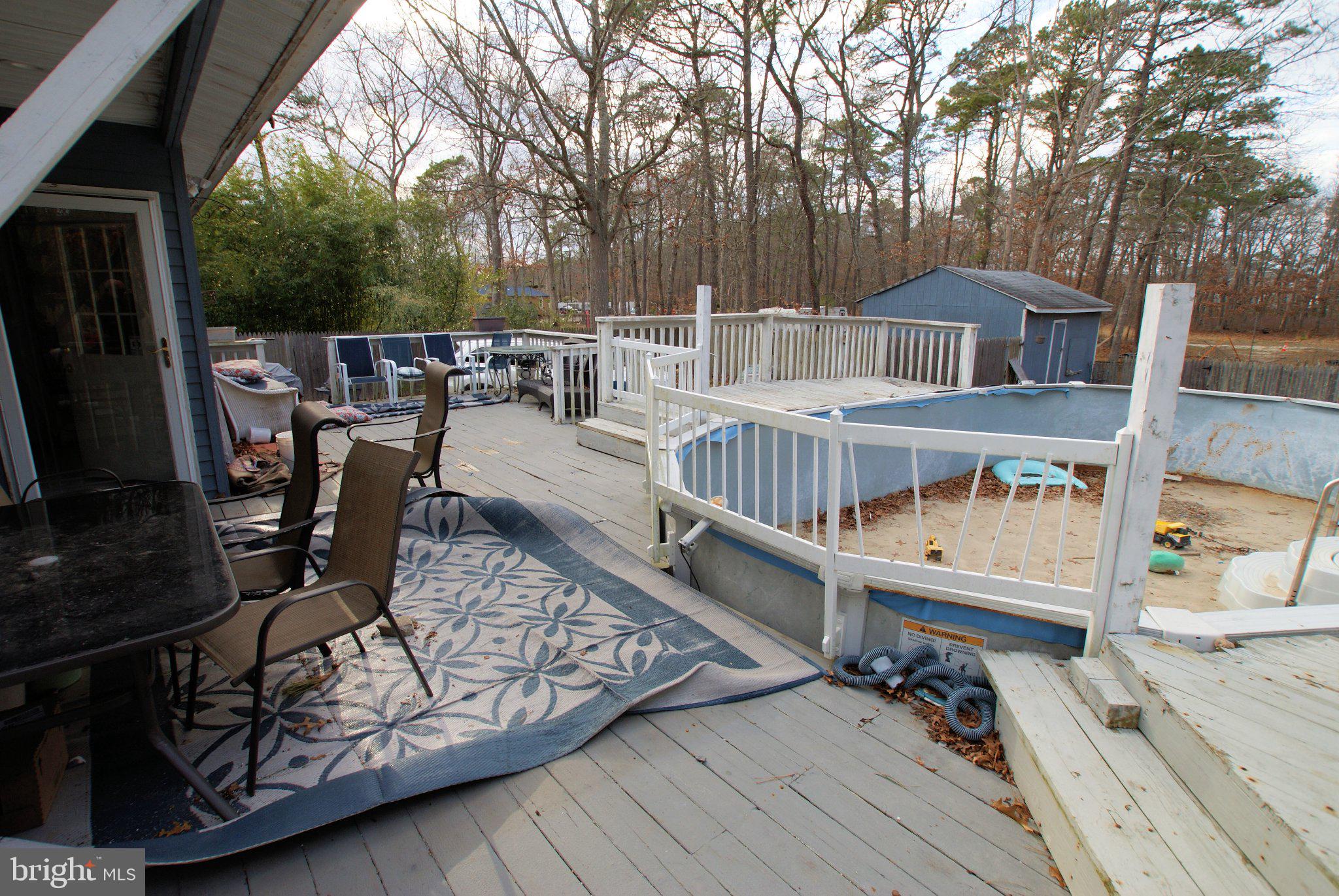 387 Frog Pond Road Little Egg Harbor, NJ 08087 - Photo 18 of 23 a view of a roof deck with table and chairs a barbeque with wooden floor and fence