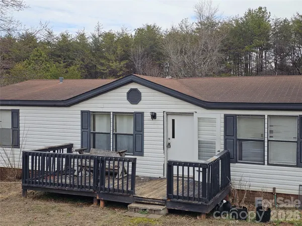 a view of a house with a yard and wooden deck