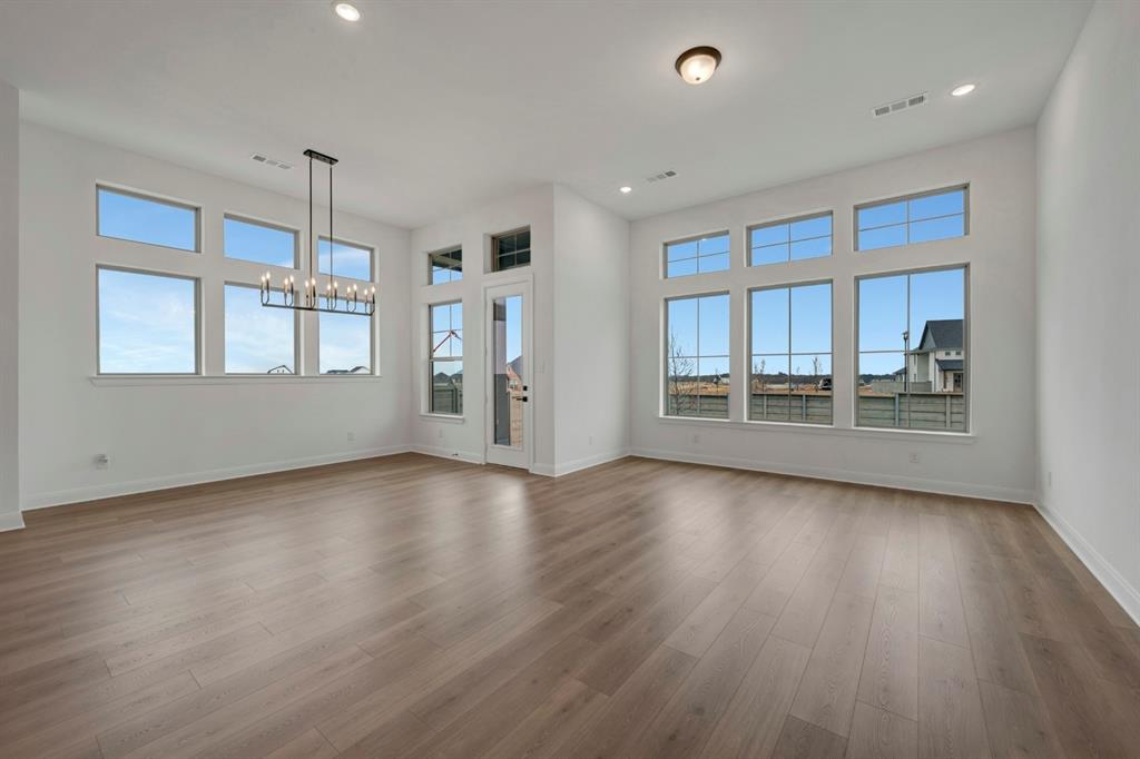 8712 Chestnut Lane Justin, TX 76247 - Photo 15 of 29 Unfurnished living room featuring a chandelier, dark wood-style flooring, and healthy amount of natural light