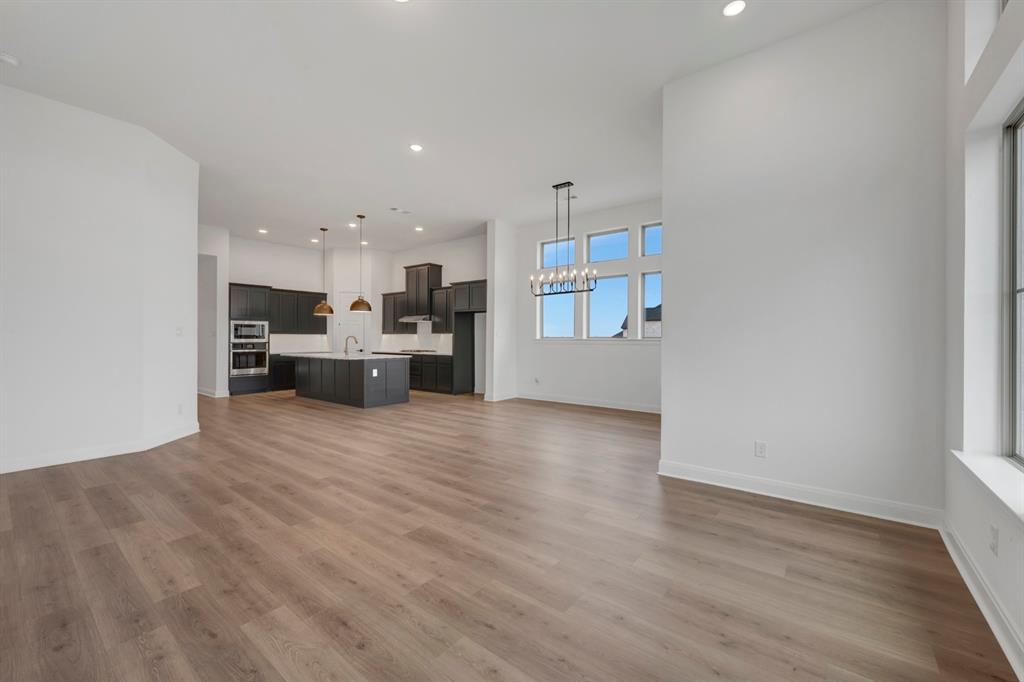 8712 Chestnut Lane Justin, TX 76247 - Photo 16 of 29 Unfurnished living room with a chandelier and light wood-style flooring