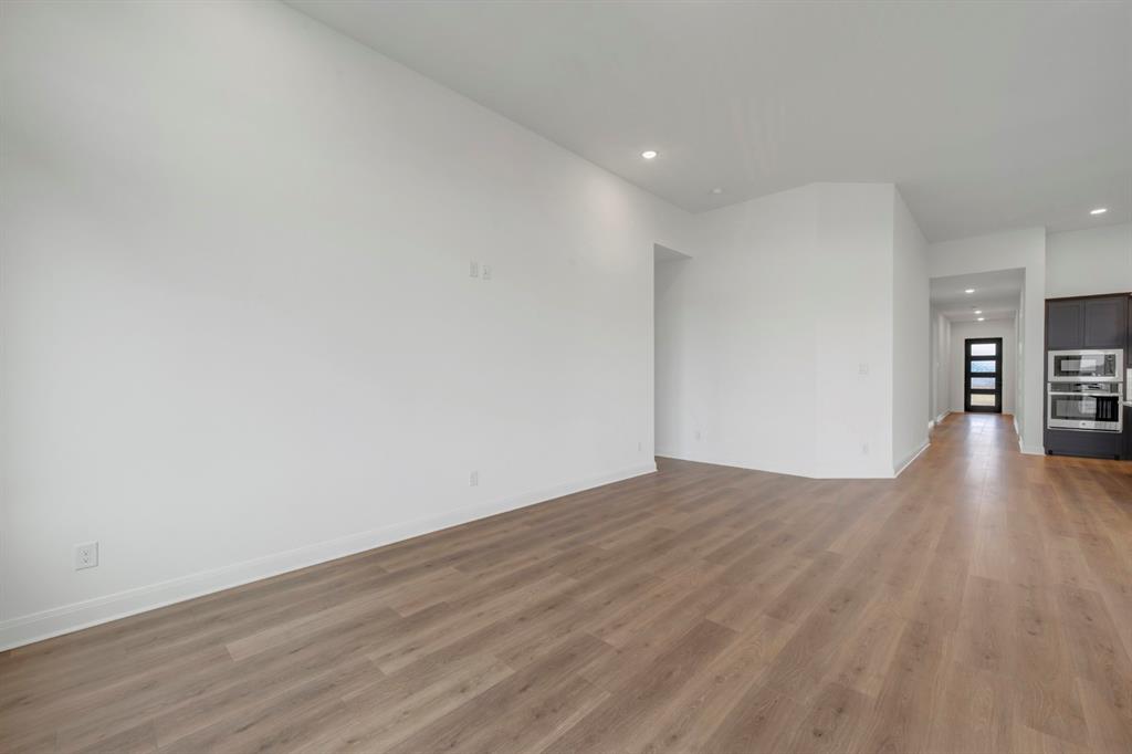 8712 Chestnut Lane Justin, TX 76247 - Photo 17 of 29 Unfurnished living room featuring recessed lighting and dark wood-style floors
