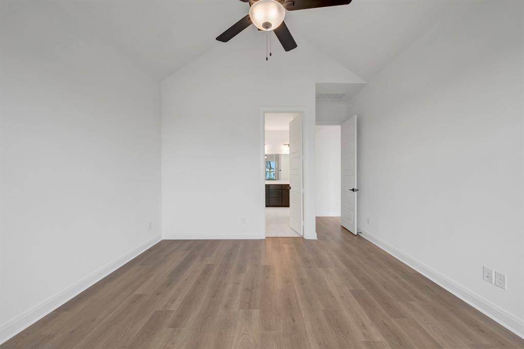 8712 Chestnut Lane Justin, TX 76247 - Photo 21 of 29 Empty room with lofted ceiling, dark wood-type flooring, and a ceiling fan