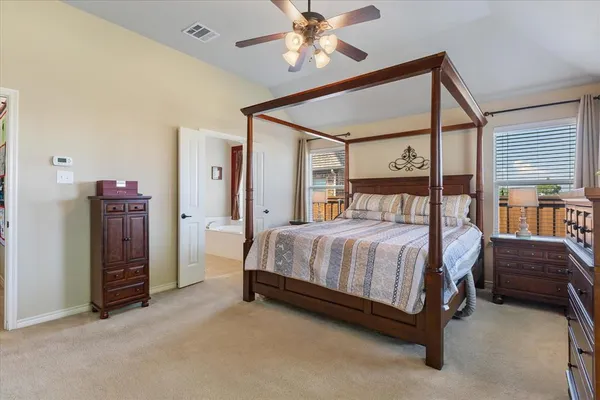 a spacious bedroom with a bed and a chandelier