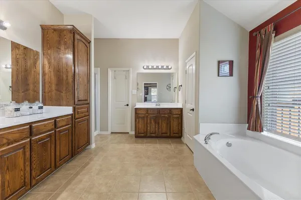 a bathroom with a tub a sink a mirror and a bathtub