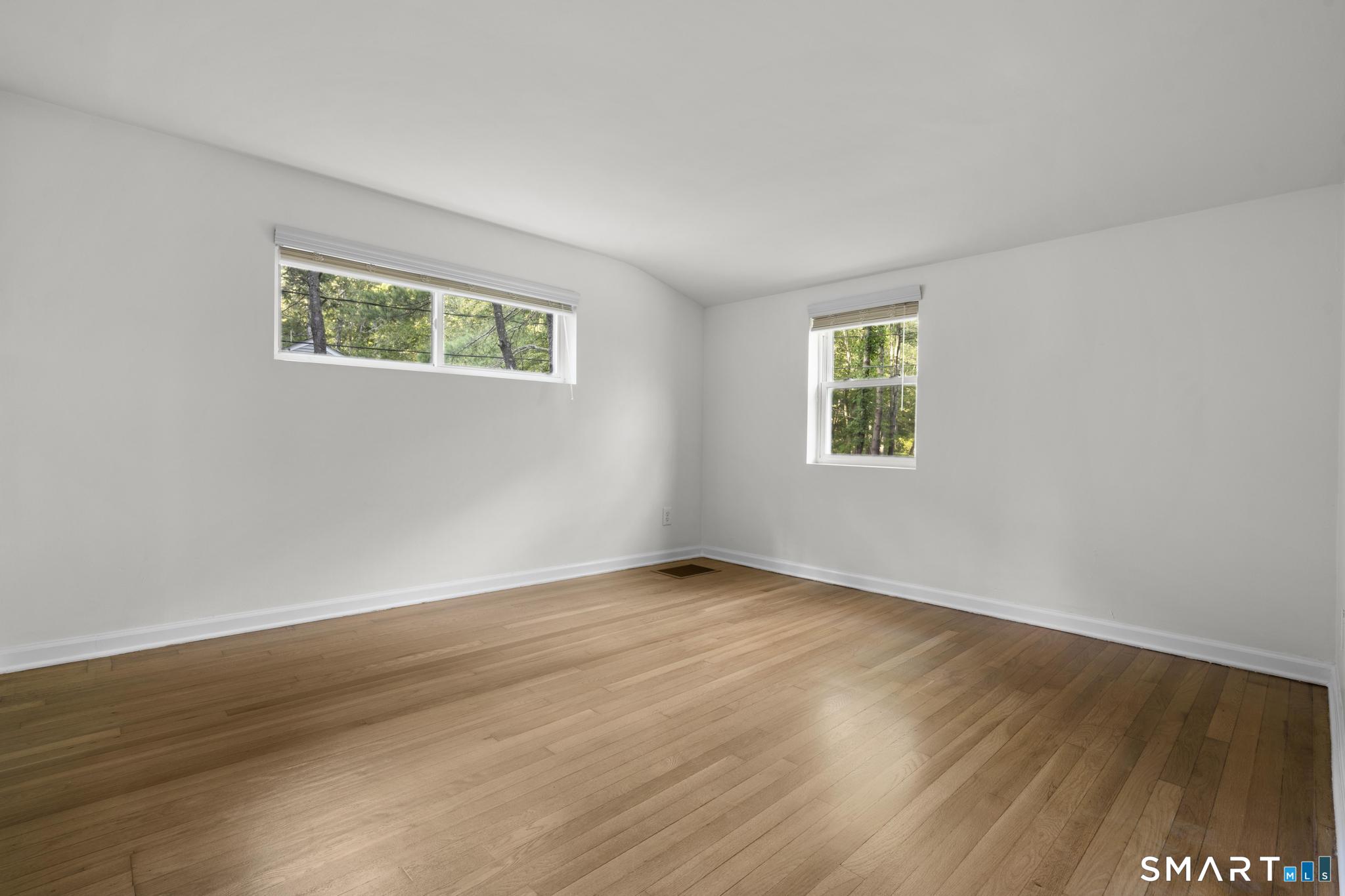 89 Book Hill Road Essex, CT 06426 - Photo 28 of 40 a view of an empty room with wooden floor and a window