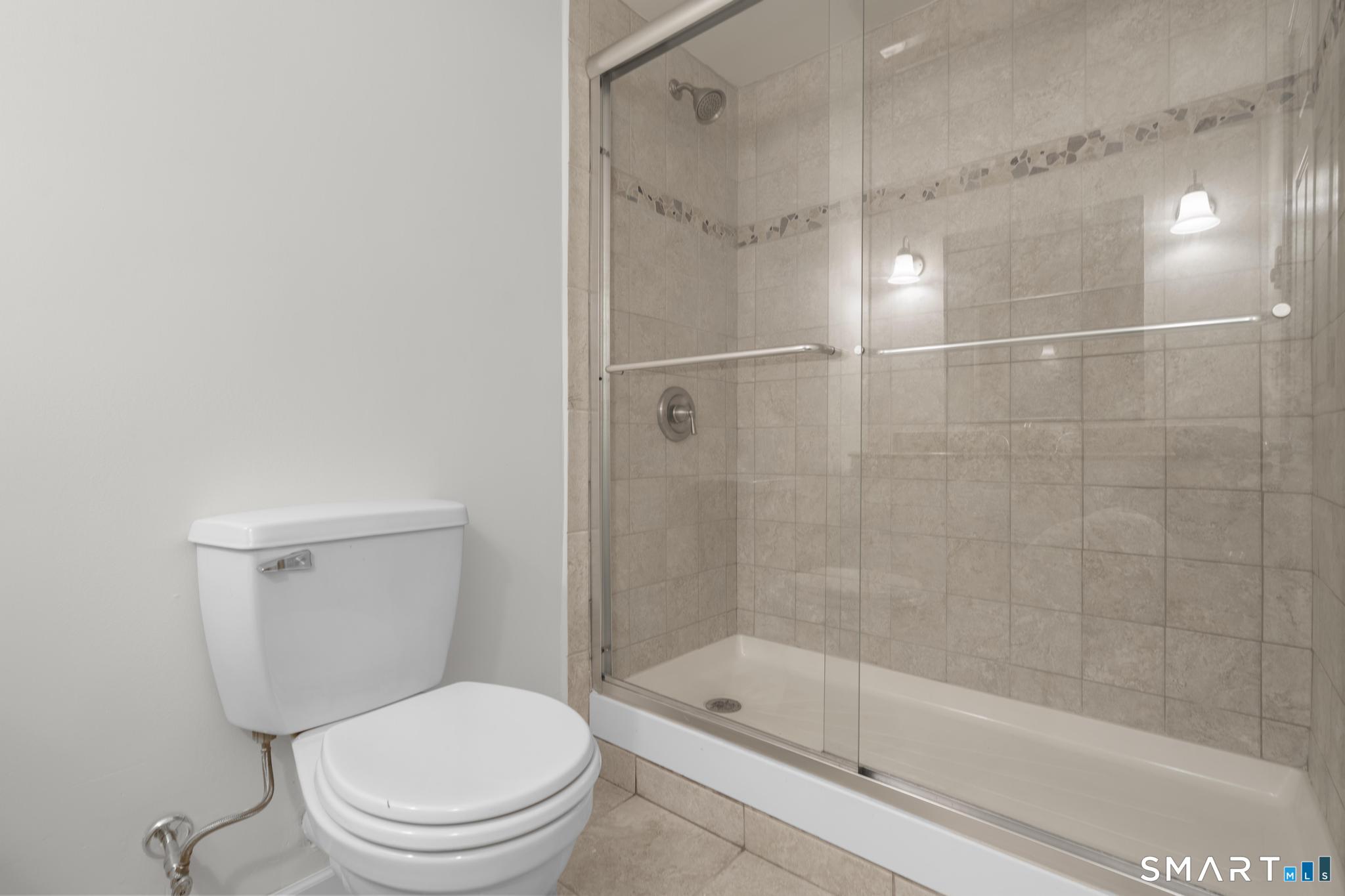 89 Book Hill Road Essex, CT 06426 - Photo 33 of 40 a bathroom with a shower a toilet and a glass window