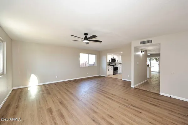 an empty room with wooden floor and windows