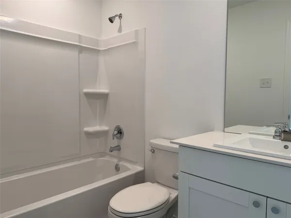 a bathroom with a sink toilet vanity and bathtub