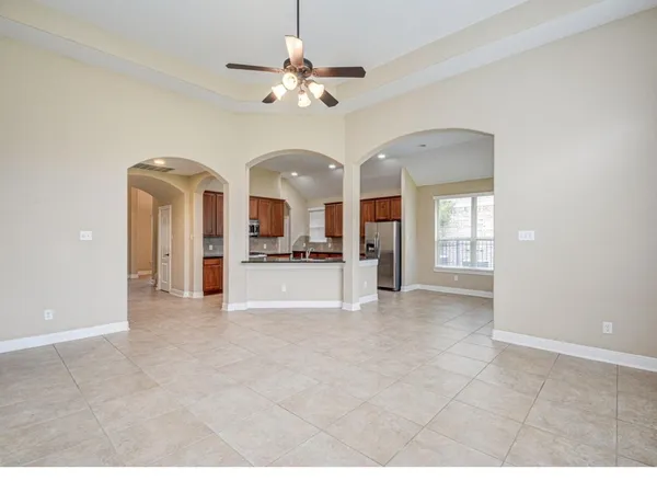 a view of a room with chandelier fan and kitchen view