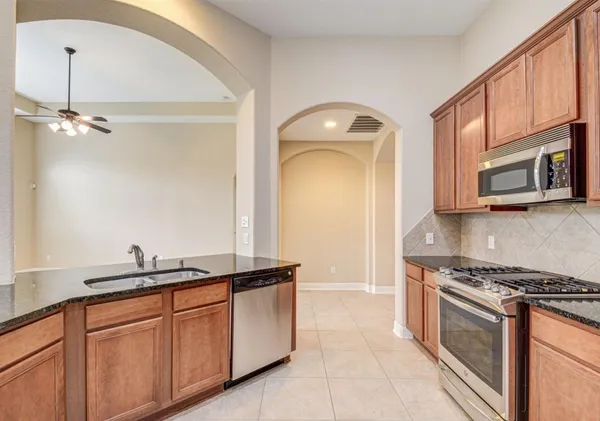a kitchen with granite countertop cabinets stainless steel appliances and a sink