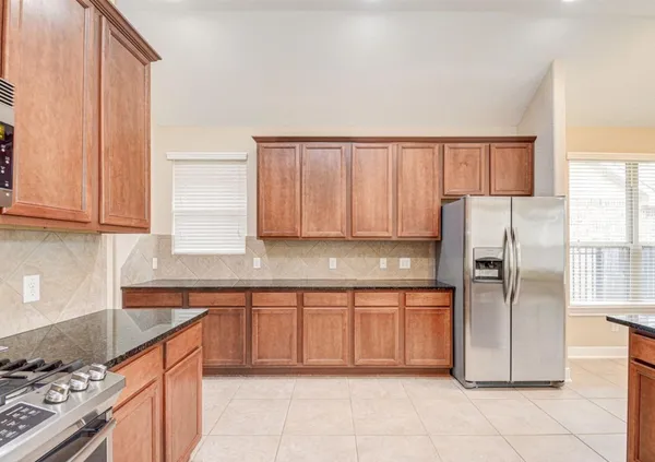 a kitchen with stainless steel appliances granite countertop a refrigerator and a stove