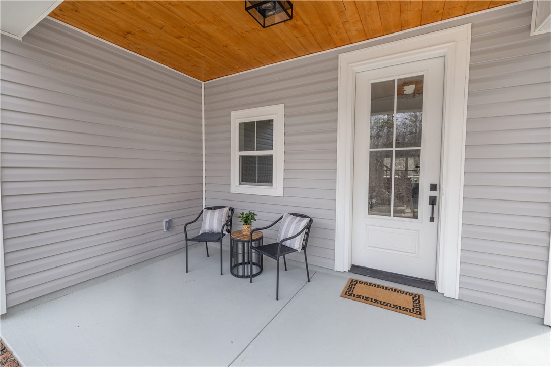 502 Point Road Westminster, SC 29693 - Photo 7 of 49 A welcoming front porch features a charming entryway with a wood plank ceiling and inviting gray siding.