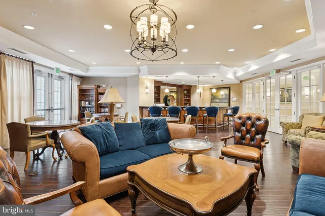 a living room with furniture kitchen view and large windows