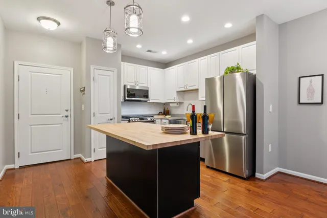 a kitchen with kitchen island a sink stainless steel appliances and refrigerator