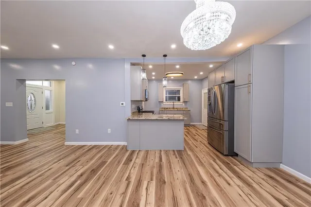 a kitchen with stainless steel appliances a refrigerator and a wooden floor