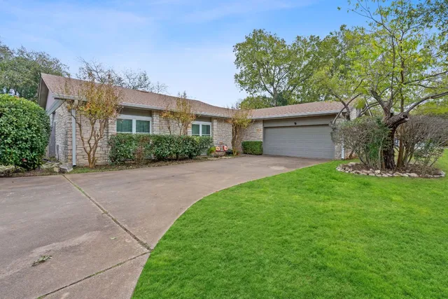 a front view of a house with a yard and a garage