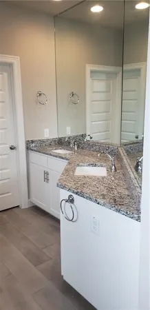 a bathroom with a granite countertop sink and a mirror