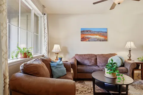 a living room with furniture and a potted plant