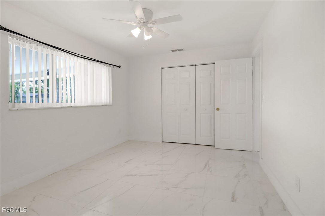 4838 Tudor Drive Cape Coral, FL 33904 - Photo 12 of 20 an empty room with windows and fan