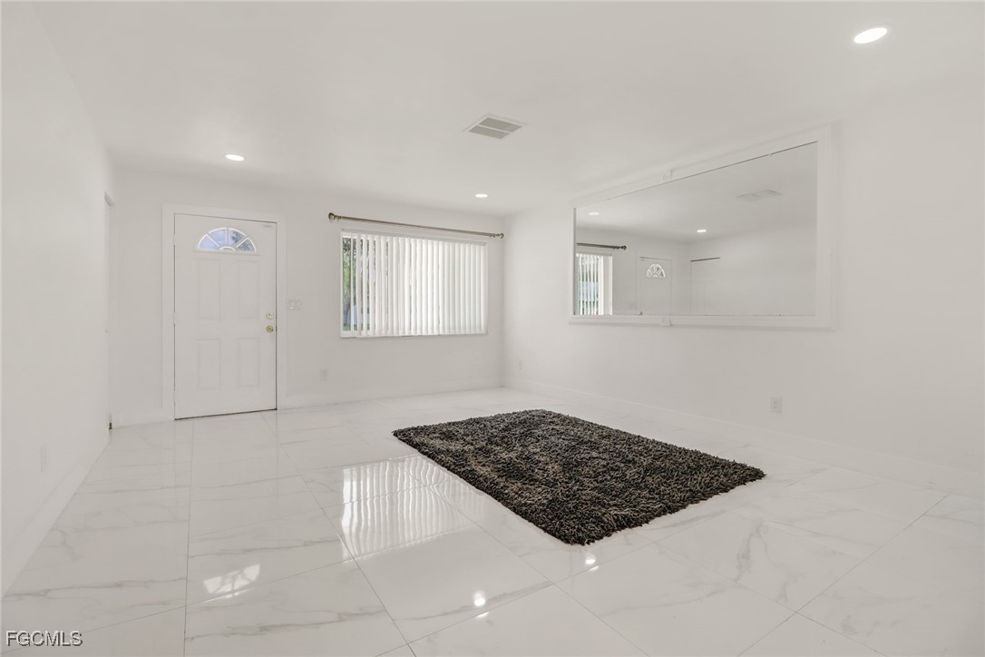 4838 Tudor Drive Cape Coral, FL 33904 - Photo 14 of 20 a view of a utility room with window and wooden floor