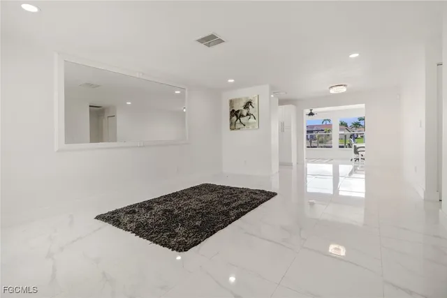 a view of a hallway to a livingroom with windows