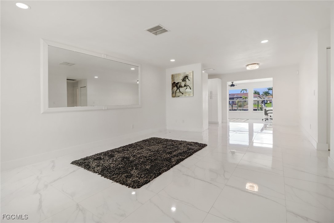 4838 Tudor Drive Cape Coral, FL 33904 - Photo 6 of 20 a view of a hallway to a livingroom with windows