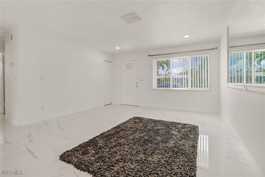 4838 Tudor Drive Cape Coral, FL 33904 - Photo 7 of 20 wooden floor in an empty room with a window
