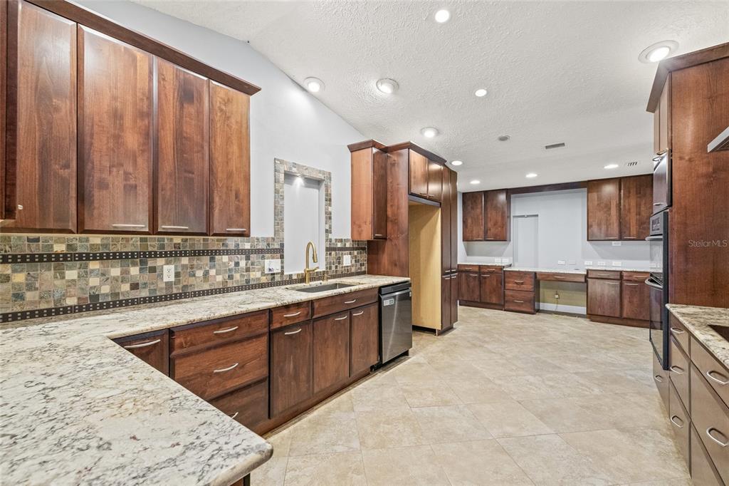 603 Cottage Grove Circle Valrico, FL 33594 - Photo 15 of 60 a large kitchen with stainless steel appliances a large counter top a stove a sink and a microwave