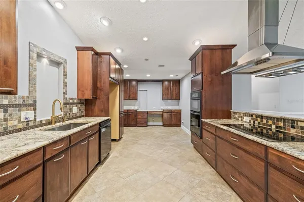 a large kitchen with stainless steel appliances granite countertop a stove and a sink