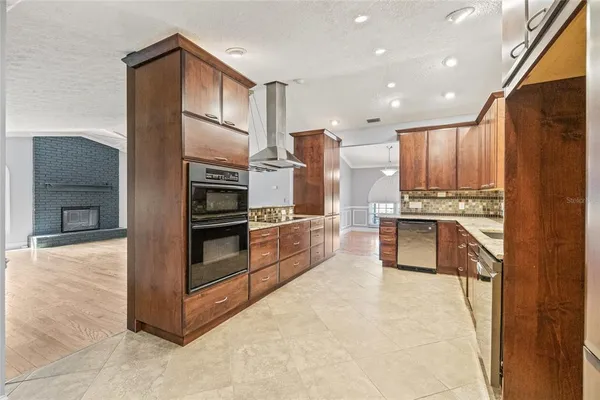a kitchen with stainless steel appliances granite countertop a refrigerator and a stove top oven
