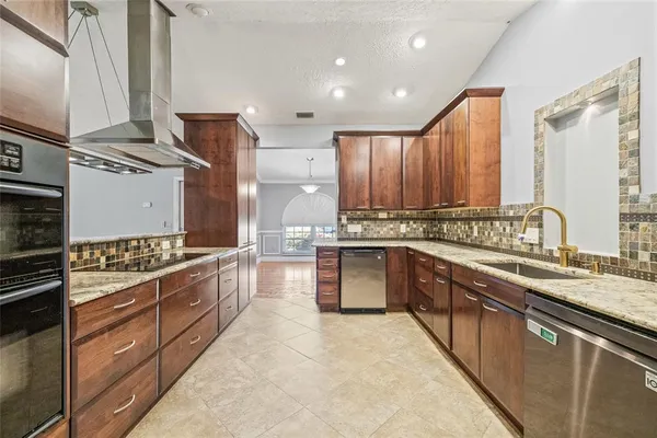 a large kitchen with stainless steel appliances granite countertop a stove a sink and a refrigerator
