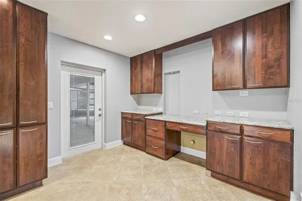 a room with stainless steel appliances granite countertop a stove a sink and a refrigerator with wooden cabinets