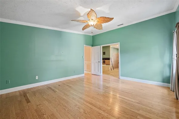 a view of an empty room with window and wooden floor