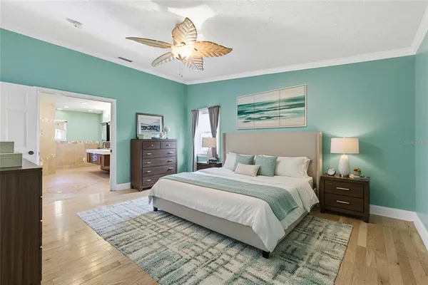 a bedroom with a large bed and a chandelier