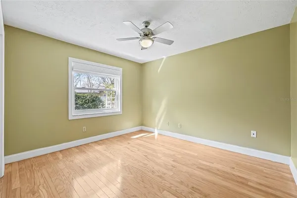 a view of a room with wooden floor and fan