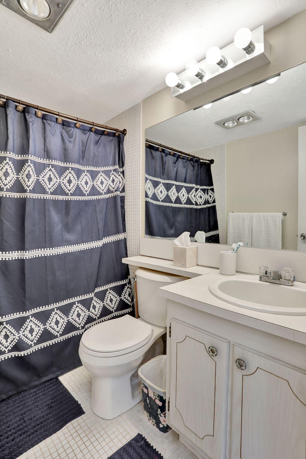 86 Lyndhurst D, Unit D Deerfield Beach, FL 33442 - Photo 9 of 42 a bathroom with a sink a toilet and a mirror