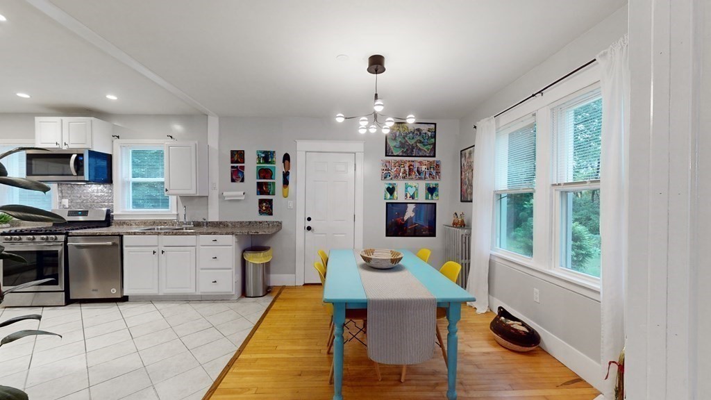 569 Mill Street Worcester, MA 01602 - Photo 4 of 24 a open kitchen with granite countertop a stove top oven a sink a dining table and chairs