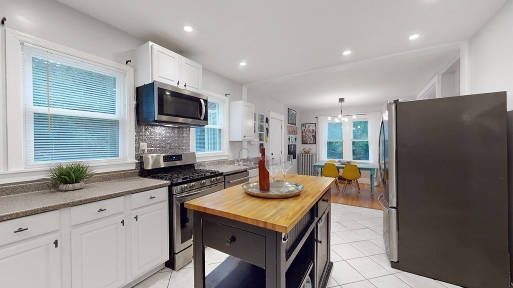 569 Mill Street Worcester, MA 01602 - Photo 6 of 24 a kitchen with stainless steel appliances granite countertop a refrigerator a sink a stove a dining table and chairs