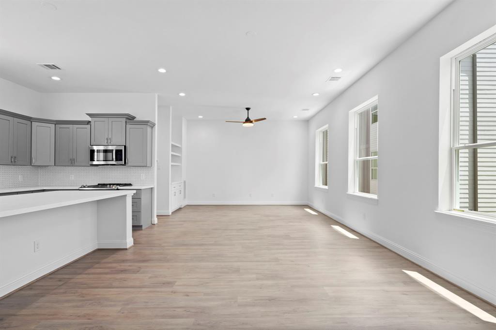 1221 West 16th Street, Unit B Houston, TX 77008 - Photo 5 of 13 a large kitchen with stainless steel appliances kitchen island a large counter top and a sink