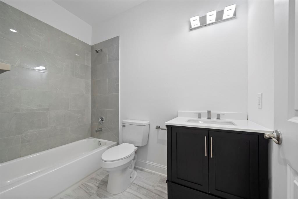 1221 West 16th Street, Unit B Houston, TX 77008 - Photo 6 of 13 a bathroom with a toilet a sink and bathtub