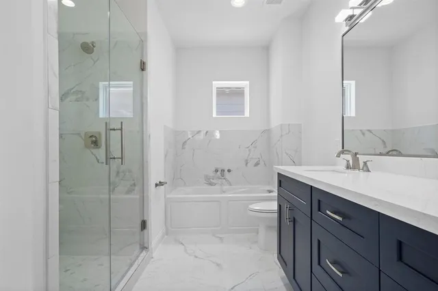 a bathroom with a bathtub shower sink mirror and toilet