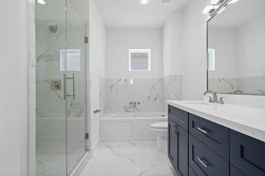 1221 West 16th Street, Unit B Houston, TX 77008 - Photo 8 of 13 a bathroom with a bathtub shower sink mirror and toilet