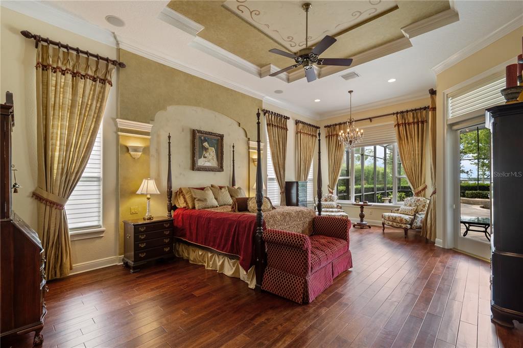 2016 Castelli Boulevard Mount Dora, FL 32757 - Photo 17 of 52 a spacious bedroom with a bed couch and a large window with wooden floor