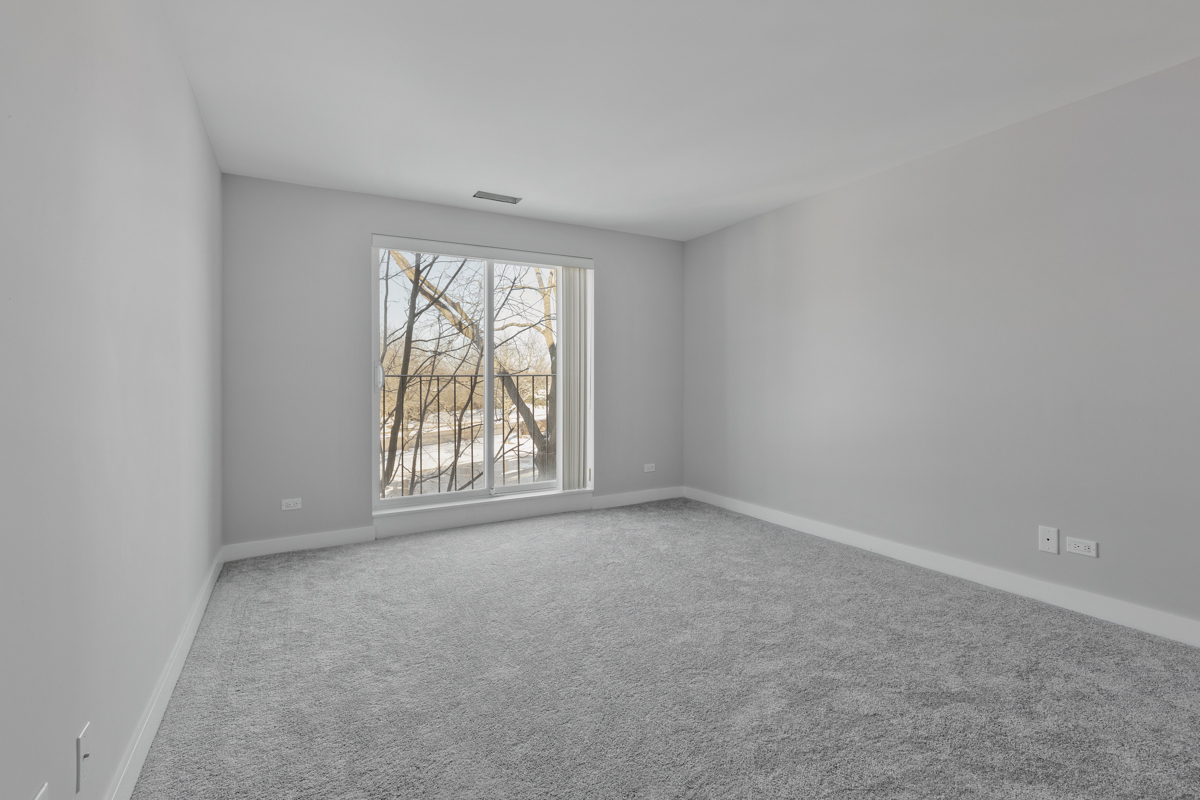 815 Leicester Road, Unit 211 Elk Grove Village, IL 60007 - Photo 13 of 19 an empty room with windows