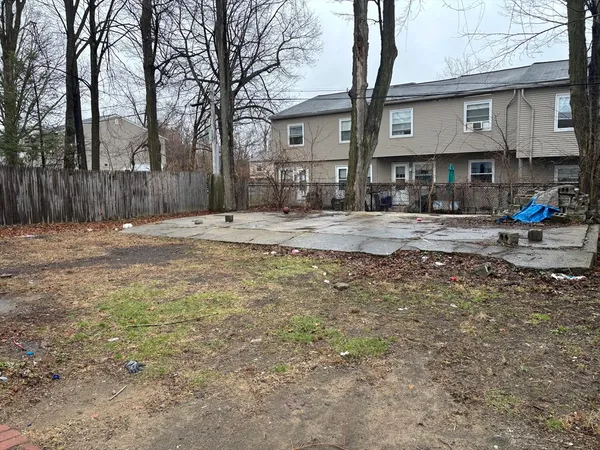 a view of a house with a yard covered in the forest
